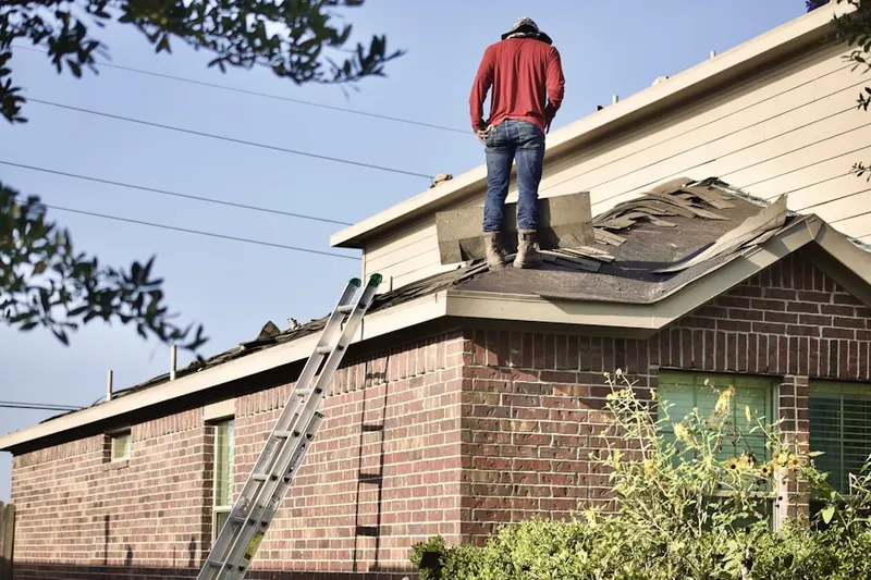 Professional roofer working on a residential roof in East Providence